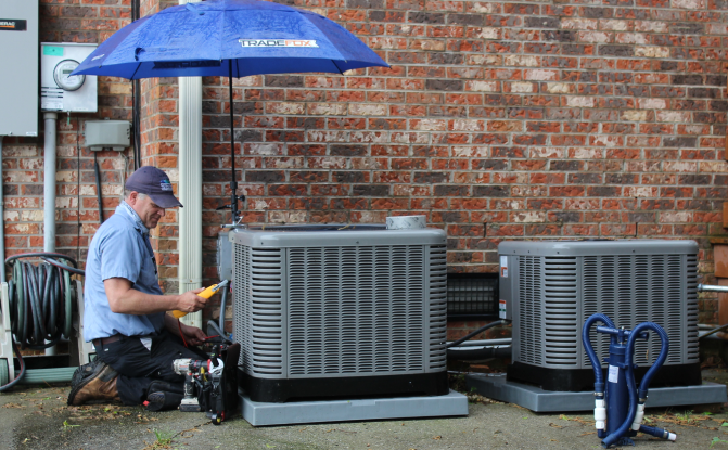 technician performing hvac repair service in the rain